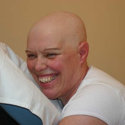 headshot of smiling woman on chair massage fully clothed